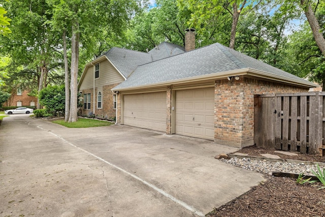 view of property exterior featuring brick siding, driveway, roof with shingles, and a garage