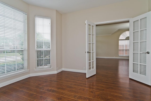 empty room featuring baseboards, french doors, and hardwood / wood-style flooring