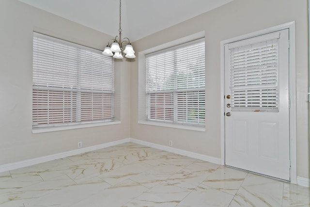 unfurnished dining area with baseboards, a notable chandelier, and marble finish floor