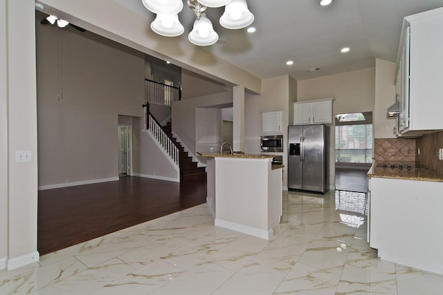 kitchen with recessed lighting, white cabinets, stone counters, a notable chandelier, and stainless steel appliances