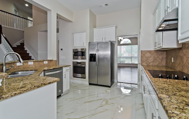 kitchen with visible vents, appliances with stainless steel finishes, a sink, light stone counters, and under cabinet range hood