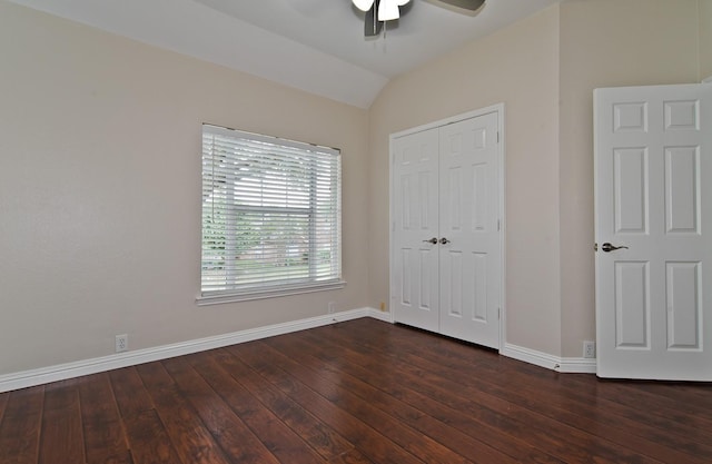 unfurnished bedroom featuring baseboards, vaulted ceiling, hardwood / wood-style flooring, and a closet