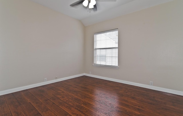 spare room with dark wood-style flooring, ceiling fan, vaulted ceiling, and baseboards