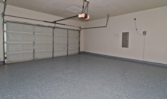 garage featuring baseboards, a garage door opener, and electric panel