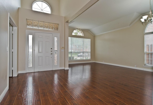 entryway featuring ornamental molding, hardwood / wood-style floors, baseboards, a notable chandelier, and vaulted ceiling