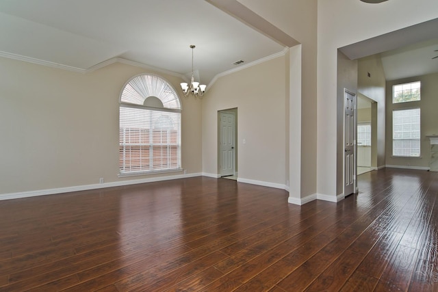 unfurnished room featuring visible vents, ornamental molding, baseboards, dark wood-style floors, and a chandelier