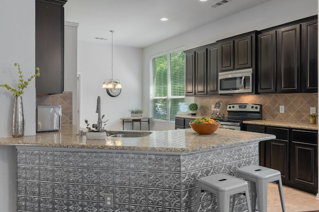 2308 Patriot Dr, Melissa, TX 75454 - kitchen featuring backsplash, light tile patterned floors, light stone counters, a sink, and stainless steel appliances