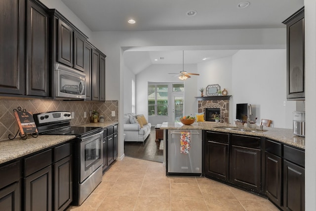 2308 Patriot Dr, Melissa, TX 75454 - kitchen with a sink, a fireplace, open floor plan, a ceiling fan, and appliances with stainless steel finishes