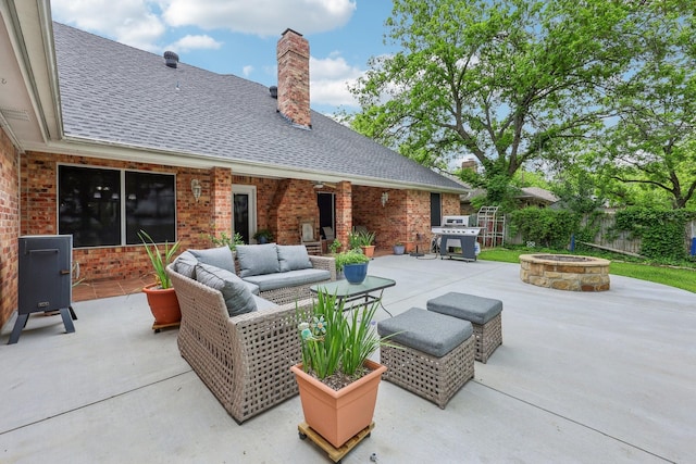 view of patio / terrace featuring fence and an outdoor living space with a fire pit