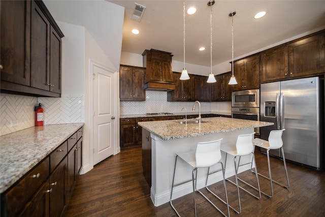kitchen featuring dark wood-style flooring, a sink, stainless steel appliances, custom range hood, and visible vents