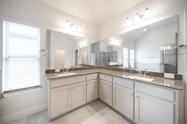full bathroom with vaulted ceiling, a shower stall, a sink, and tile patterned flooring