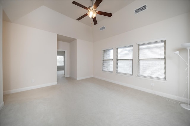 unfurnished room with baseboards, ceiling fan, light carpet, and visible vents