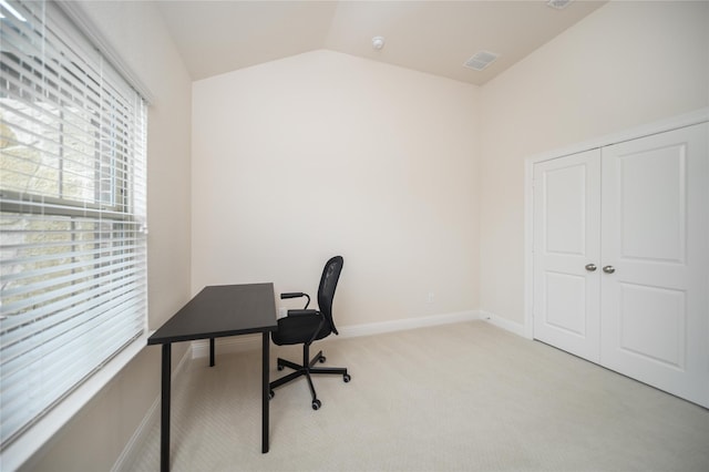 office featuring visible vents, baseboards, vaulted ceiling, and light carpet