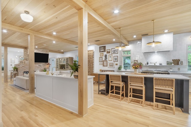 417 N Waddill St, Mckinney, TX 75069 - kitchen featuring light wood-type flooring, wooden ceiling with exposed beams, decorative backsplash, light countertops, and a breakfast bar