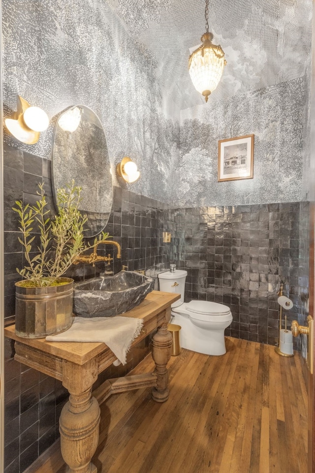 417 N Waddill St, Mckinney, TX 75069 - bathroom featuring toilet, tile walls, a sink, and hardwood / wood-style floors
