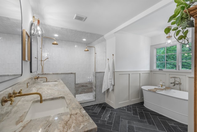 417 N Waddill St, Mckinney, TX 75069 - full bath with a tile shower, double vanity, a freestanding bath, wainscoting, and a decorative wall