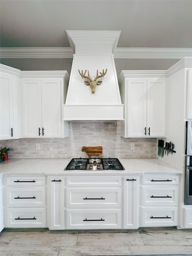 kitchen with premium range hood, ornamental molding, stainless steel appliances, and white cabinets
