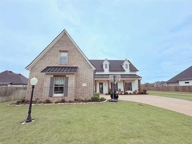 view of front of house with fence, a standing seam roof, metal roof, and a front yard