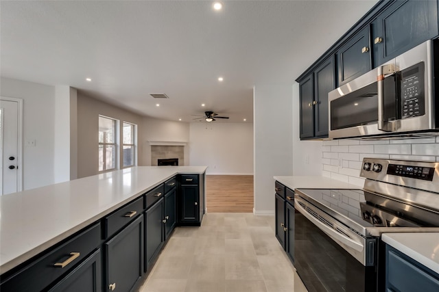 kitchen featuring ceiling fan, appliances with stainless steel finishes, light countertops, tasteful backsplash, and visible vents