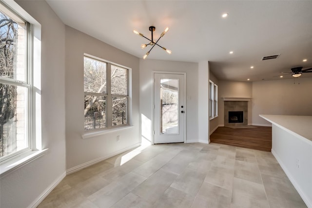 entryway with a notable chandelier, a fireplace, recessed lighting, baseboards, and visible vents