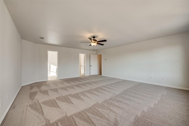 unfurnished room with baseboards, light carpet, a ceiling fan, and visible vents