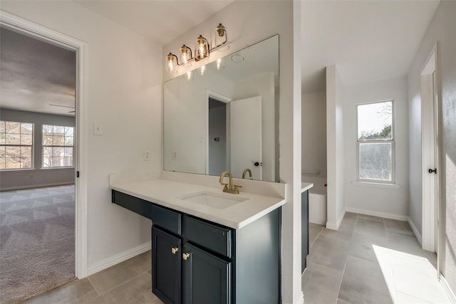 bathroom with vanity, tile patterned flooring, and baseboards