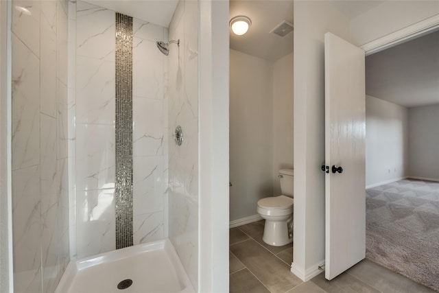 bathroom featuring toilet, baseboards, visible vents, and a marble finish shower