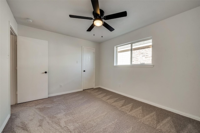 unfurnished bedroom featuring carpet floors, baseboards, and ceiling fan
