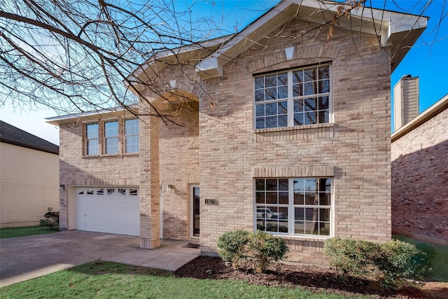 traditional-style house with concrete driveway, brick siding, and a garage
