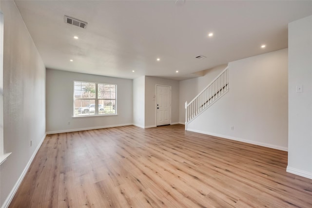 unfurnished living room with visible vents, recessed lighting, light wood-style floors, and stairway