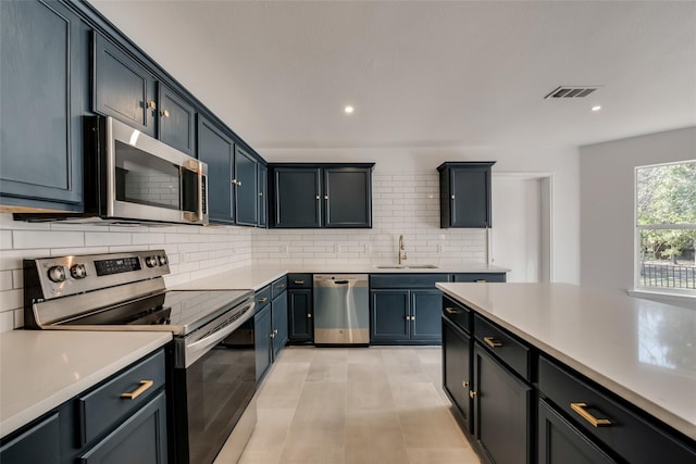 kitchen with backsplash, visible vents, a sink, light countertops, and stainless steel appliances