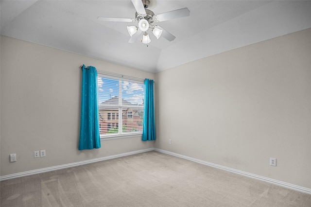 carpeted spare room with baseboards, a ceiling fan, and vaulted ceiling