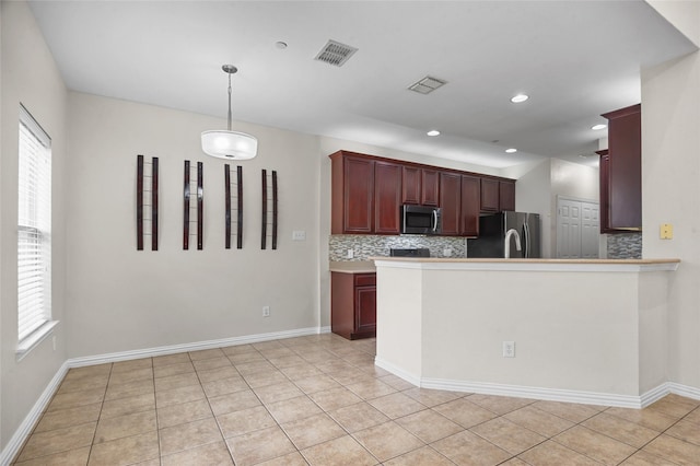 kitchen featuring appliances with stainless steel finishes, tasteful backsplash, decorative light fixtures, and visible vents