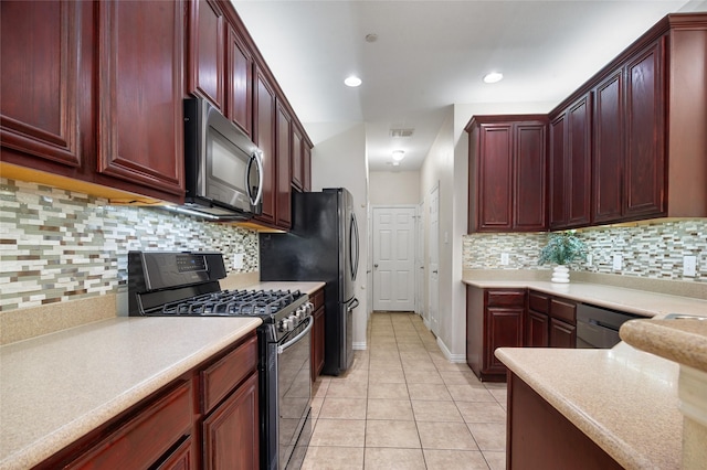 kitchen with visible vents, light countertops, light tile patterned floors, reddish brown cabinets, and stainless steel appliances