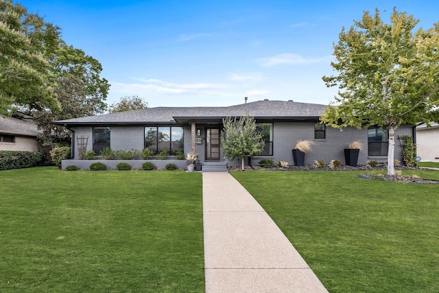 ranch-style home featuring roof with shingles, a front lawn, and brick siding