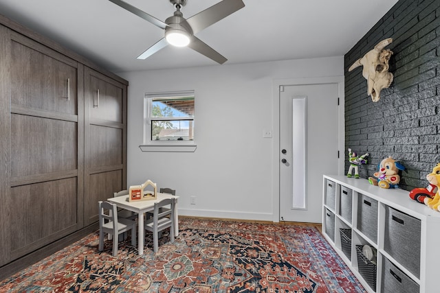 recreation room featuring a ceiling fan and baseboards