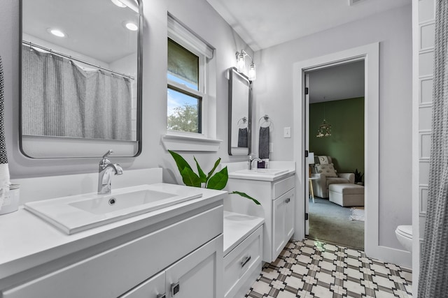 full bath with recessed lighting, tile patterned floors, two vanities, and a sink