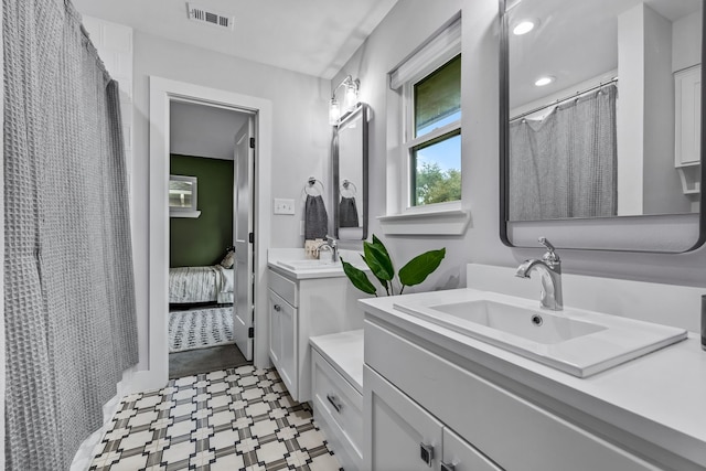 full bathroom with a sink, tile patterned floors, two vanities, ensuite bathroom, and visible vents