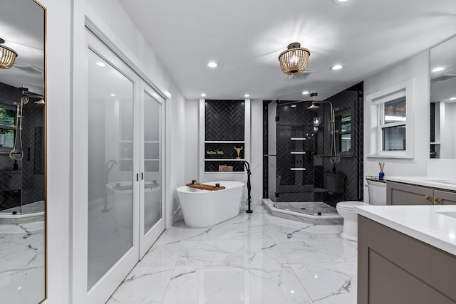 bathroom featuring vanity, marble finish floor, recessed lighting, a soaking tub, and a stall shower