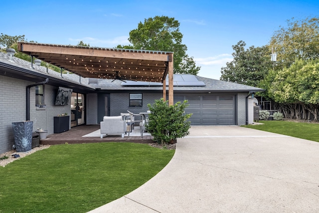 back of property featuring a yard, brick siding, and roof mounted solar panels