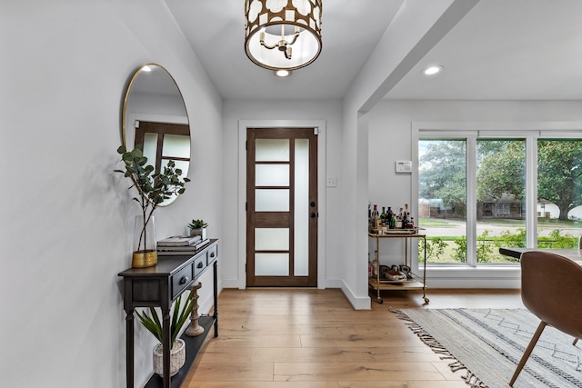 entryway with baseboards, recessed lighting, light wood-style flooring, and a notable chandelier