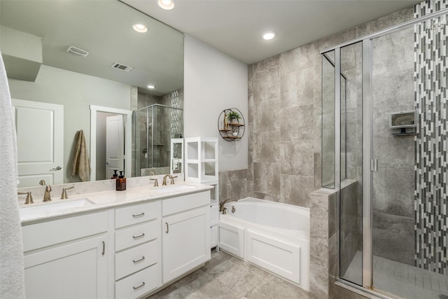 bathroom featuring visible vents, a sink, a garden tub, and a stall shower