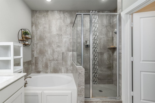 bathroom featuring a shower stall, a bath, and vanity