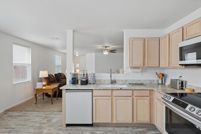 712 Riverflat Dr, Fort Worth, TX 76179 - kitchen with ceiling fan, stainless steel range with electric cooktop, a sink, light wood finished floors, and light brown cabinets