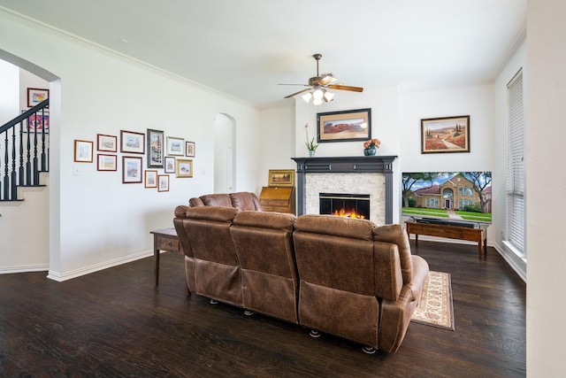 5624 Big River Dr, The Colony, TX 75056 - living room featuring wood finished floors, ceiling fan, arched walkways, baseboards, and a stone fireplace