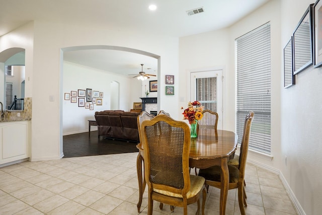 5624 Big River Dr, The Colony, TX 75056 - dining room featuring baseboards, light tile patterned flooring, ceiling fan, and arched walkways