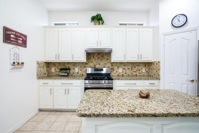 5624 Big River Dr, The Colony, TX 75056 - kitchen with tasteful backsplash, light stone counters, under cabinet range hood, gas stove, and white cabinets