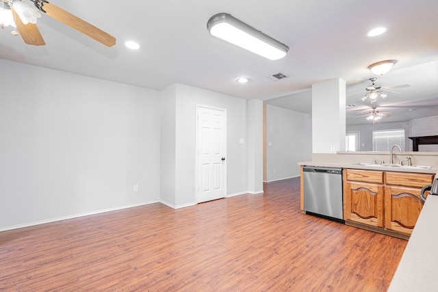 kitchen featuring ceiling fan, stainless steel dishwasher, a sink, light countertops, and light wood-style floors