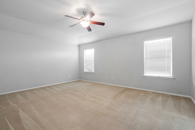 spare room with carpet flooring, a ceiling fan, and baseboards