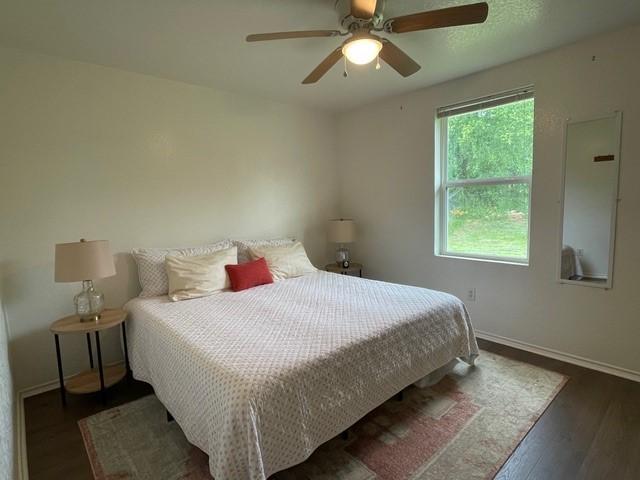 bedroom with baseboards, ceiling fan, and wood finished floors